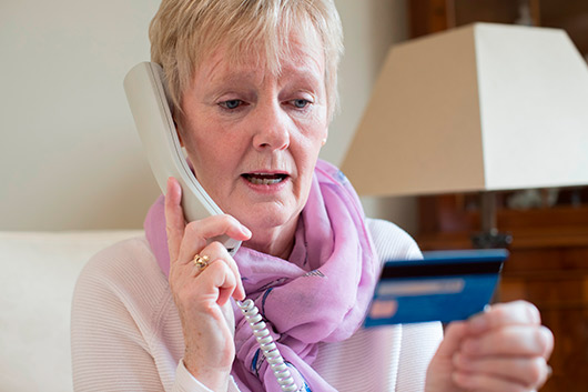 woman doing a call with a card, credit card in their hands. Telephone banking