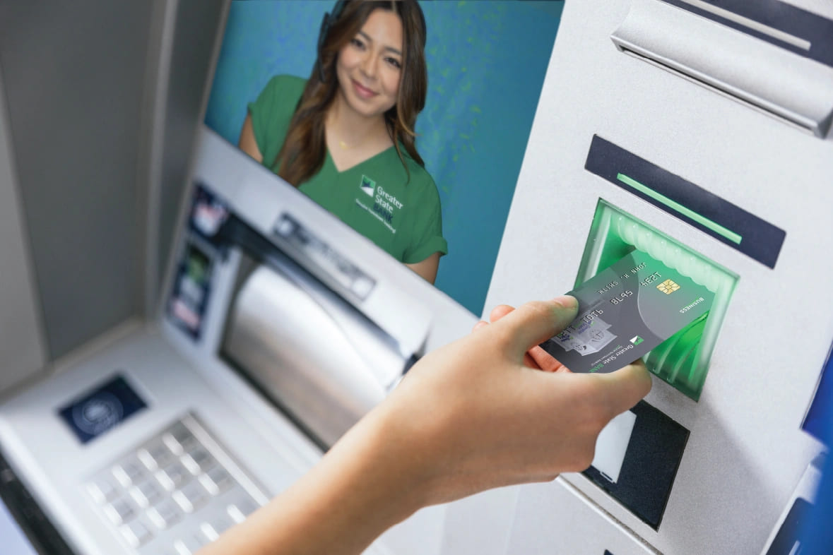 A person using a Greater State Bank ATM to complete a transaction